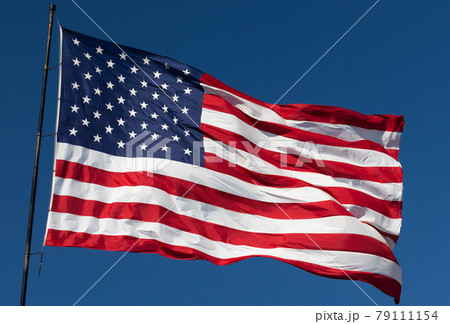 American Flag Waving In Wind Against a Deep Blue Sky. 79111154