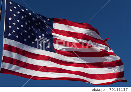 American Flag Waving In Wind Against a Deep Blue Sky. American Flag Waving In Wind Against a Deep Blue Sky. 79111157