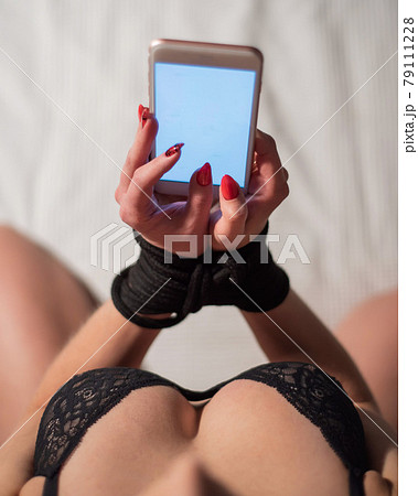 Top view of a woman with big breasts on a bed - Stock Photo