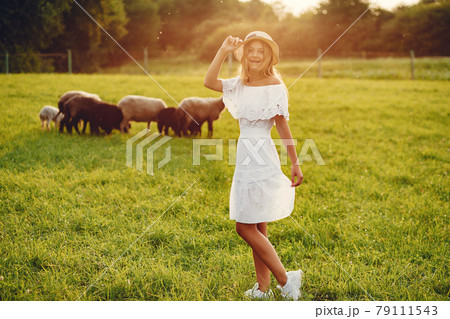 Cute girl in a field with a goats Cute girl in a field with a goats 79111543