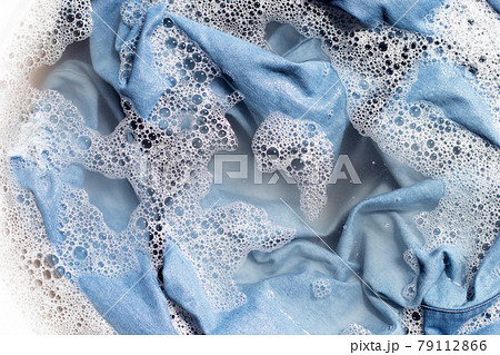Jean shirt soak in powder detergent water dissolution, washing cloth. Laundry concept Jean shirt soak in powder detergent water dissolution, washing cloth. Laundry concept 79112866