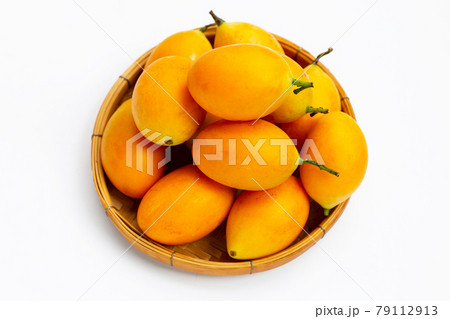 Marian plum fruit in bamboo basket on white background. 79112913