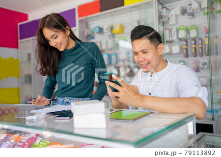 a business man using a smartphone and a business woman using a calculator a business man using a smartphone and a business woman using a calculator 79113892