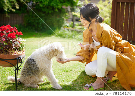 庭で愛犬と戯れるミドル女性 79114170