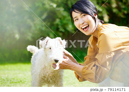 庭で愛犬と戯れるミドル女性 庭で愛犬と戯れるミドル女性 79114171