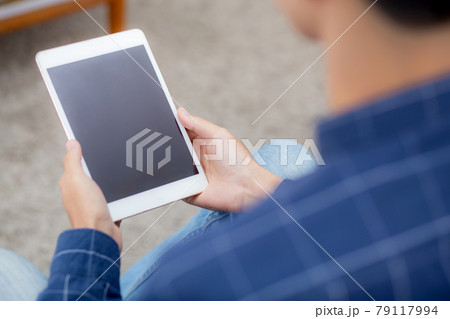 Closeup young asian man sitting and using mockup of tablet computer with display blank screen. 79117994