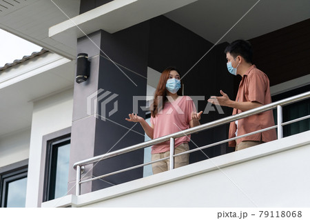 stressed couple wearing a face mask and quarantine in balcony of home, coronavirus (covid-19) pandemic concept 79118068