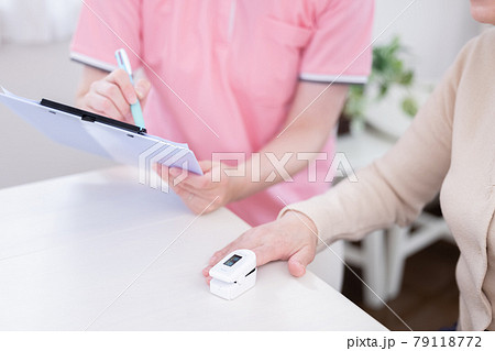 介護　パルスオキシメーターで酸素濃度を測るシニア女性の手元 79118772