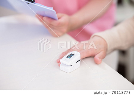 介護　パルスオキシメーターで酸素濃度を測るシニア女性の手元 79118773