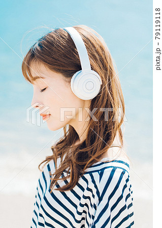 海で音楽を聴く女性 79119118