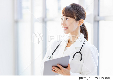タブレットPCを持ってフレーム外を見る女性医師 タブレットPCを持ってフレーム外を見る女性医師 79119306