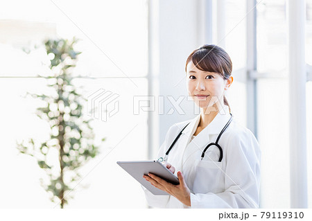 病院内でタブレットPCを持って立つ女性医師 79119310