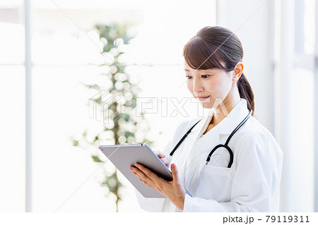 病院内でタブレットPCを持って立つ女性医師 79119311