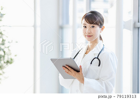 病院内でタブレットPCを持って立つ女性医師 79119313