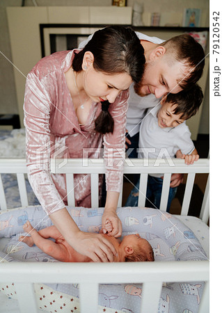 Happy family with a toddler near the children's cradle.  79120542