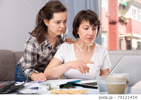 Portrait of serious women working with documents and using laptop 79121450