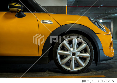 Side view of Headlights, Wheel, Hood, Sidelights and Side view mirror of Yellow car. 79121715