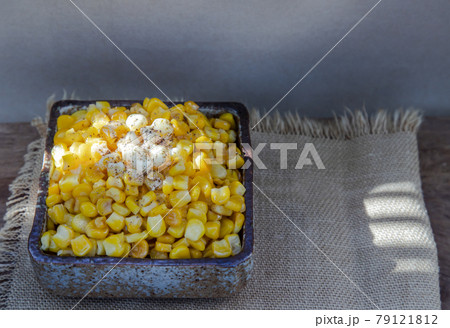 Fried sweet corn with a knob of butter and seasonings Sprinkle with ground black pepper in ceramic bowl and spoon. Fried sweet corn with a knob of butter and seasonings Sprinkle with ground black pepper in ceramic bowl and spoon. 79121812