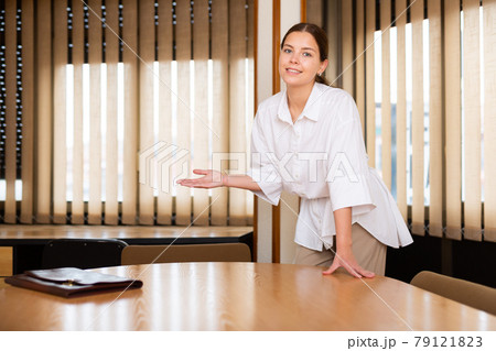 Portrait of a young positive businesswoman standing in the conference hall Portrait of a young positive businesswoman standing in the conference hall 79121823