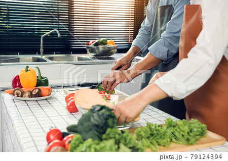 Asian Couple having fun while cooking a meal in kitchen. Asian Couple having fun while cooking a meal in kitchen. 79124394