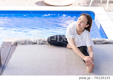 プールサイドでヨガをする若い女性 79126133