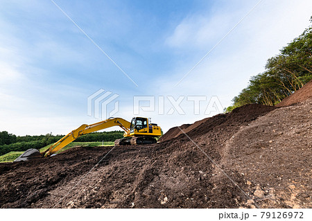 重機油圧シャベルと木片の山 79126972