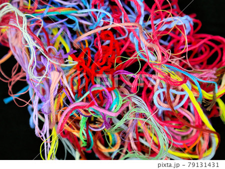 Close-up of multicolored tangled threads for needlework on black background 79131431