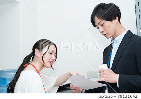 コピー機の前で書類について話し合う上司と部下 79131642