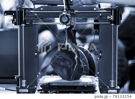 3D printer printing a model in the form of black vase close-up. 79133254