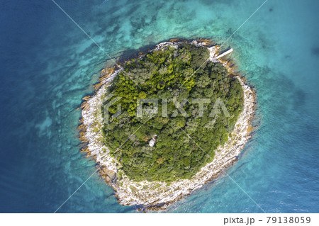 Vertical top view on a small island in the mediterrean sea close to the shore 79138059