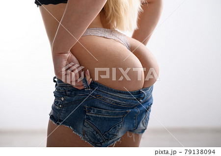 Blonde with long hair puts on denim shorts. A - Stock Photo [79138094] -  PIXTA