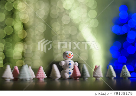Cute snowman and little Christmas trees made of marshmallows on the background of Christmas lights. Garland of light bulbs on a tree. Happy new year. Cute snowman and little Christmas trees made of marshmallows on the background of Christmas lights. Garland of light bulbs on a tree. Happy new year. 79138179