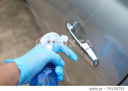 hand in spry bottle cleaning car door knob hand in spry bottle cleaning car door knob 79138792