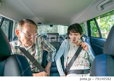 シニアカップル 車 後部座席 シートベルトの写真素材