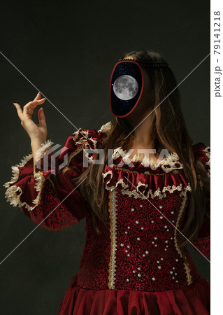 Female model like medieval royalty person in vintage clothing. Concept of comparison of eras, artwork, renaissance, baroque style. Creative collage. Surrealism 79141218