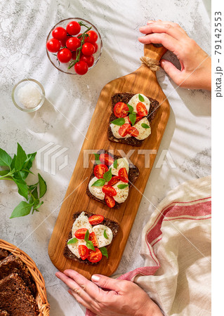 Whole wheat bread sandwiches with cheese, tomatoes and basil leaves. Healthy snack concept. Whole wheat bread sandwiches with cheese, tomatoes and basil leaves. Healthy snack concept. 79142553