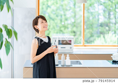 キッチンで水分補給する女性。 キッチンで水分補給する女性。 79145914