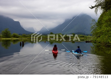 Adventure Friends Kayaking in Kayak surrounded by Canadian Mountain Landscape Adventure Friends Kayaking in Kayak surrounded by Canadian Mountain Landscape 79148513