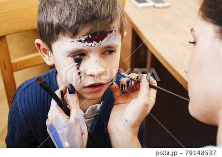 little cute child making facepaint on birthday party, zombie Apocalypse facepainting, halloween preparing concept, lifestyle people 79148537
