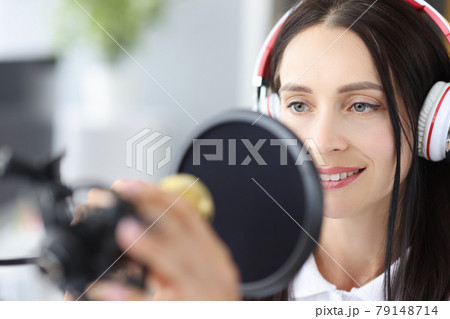 Portrait of young woman radio presenter announces news at workplace 79148714