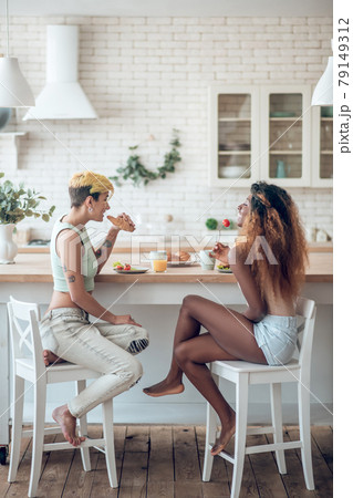 African american and caucasian girlfriend are relaxed eating. African american and caucasian girlfriend are relaxed eating. 79149312