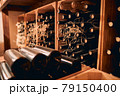 Wooden racks with wine bottles in storage room 79150400