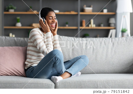 Domestic Pastime. Joyful African Female Listening Music In Wireless Headphones At Home Domestic Pastime. Joyful African Female Listening Music In Wireless Headphones At Home 79151842