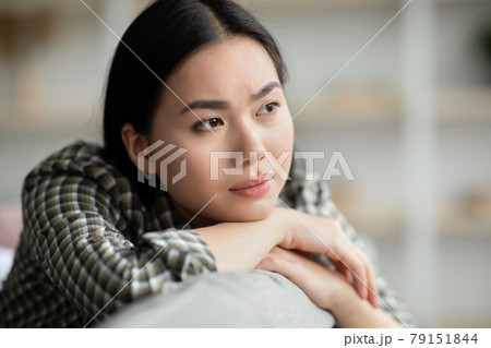 Closeup of upset young woman sitting on couch and crying 79151844