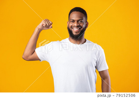 Cheerful Black Guy Showing Biceps Muscles Posing On Yellow Background Cheerful Black Guy Showing Biceps Muscles Posing On Yellow Background 79152506
