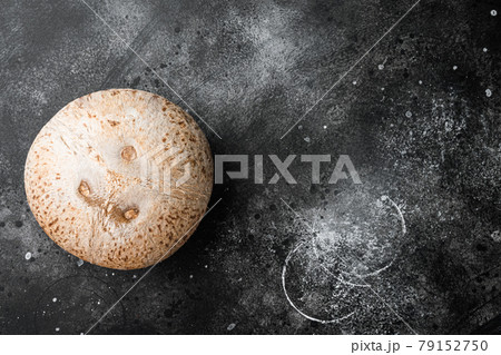 Freshly harvested coconut, on black dark stone table background, top view flat lay, with copy space for text 79152750