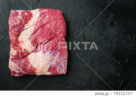 Beef navel, raw beef brisket meat, on black stone background, top view flat lay, with copy space for text Beef navel, raw beef brisket meat, on black stone background, top view flat lay, with copy space for text 79152757