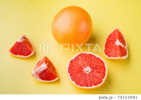 Juicy pink grapefruit cut , on yellow textured summer background Juicy pink grapefruit cut , on yellow textured summer background 79153091