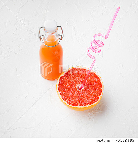 Pink grapefruit juice, square format, on white stone table background 79153395