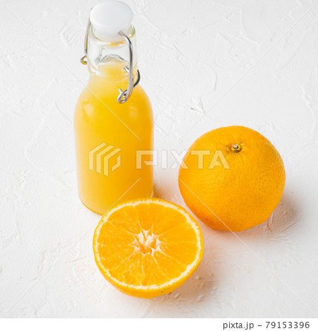 Glass jar of fresh Tangerine juice, square format, on white stone table background Glass jar of fresh Tangerine juice, square format, on white stone table background 79153396